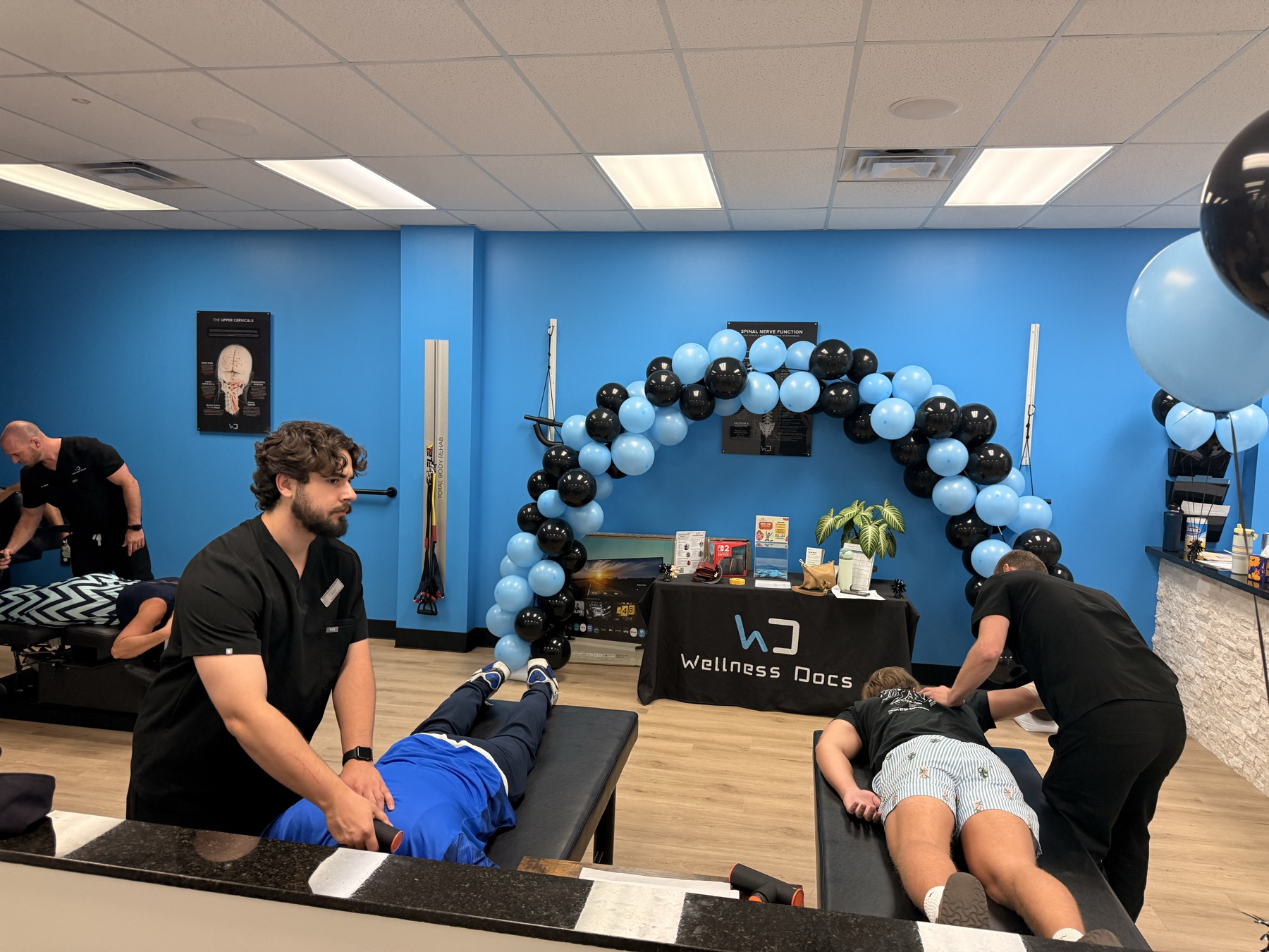Providers working with guests beside the balloon arch